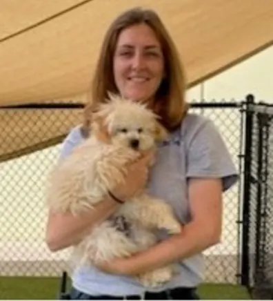 Scarlett, trainer at Elite Suites, holding a dog